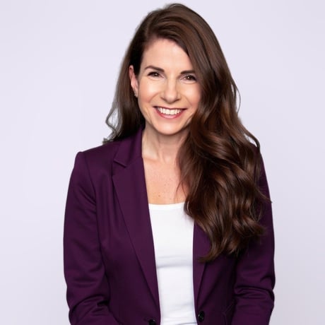 Summer Hagens, founder of Authentically 23, smiling in a plum blazer